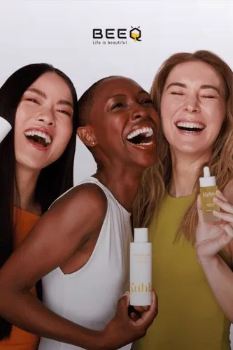 Three smiling women with cosmetic products, BeeQ campaign