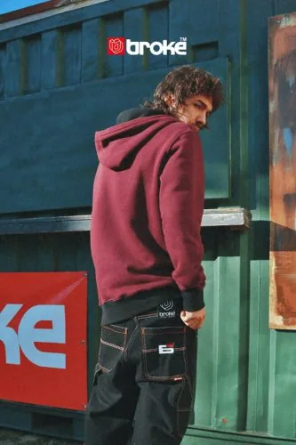 Young man seen from behind in a burgundy sweatshirt, Brokė campaign, streetwear