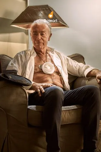 Elderly man in an armchair with a medical device, D-Heart campaign